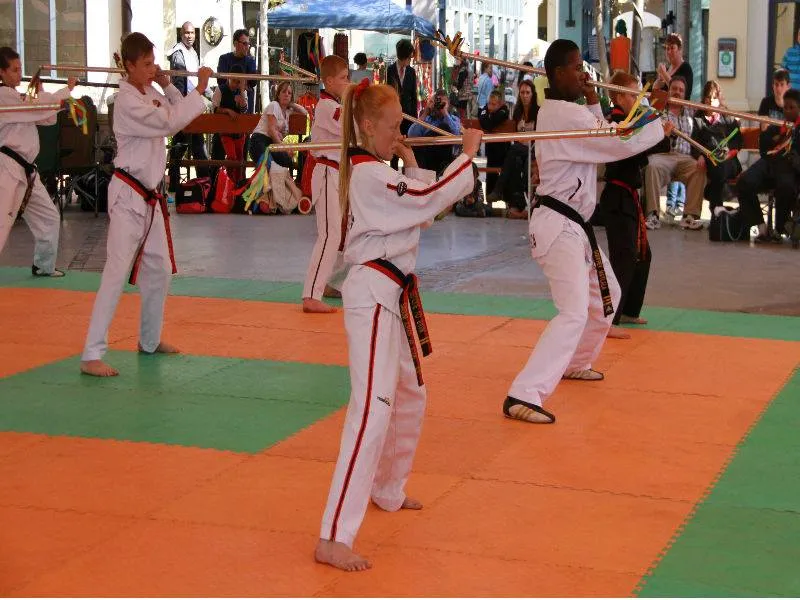 A student performing a long staff pattern in the dojang.